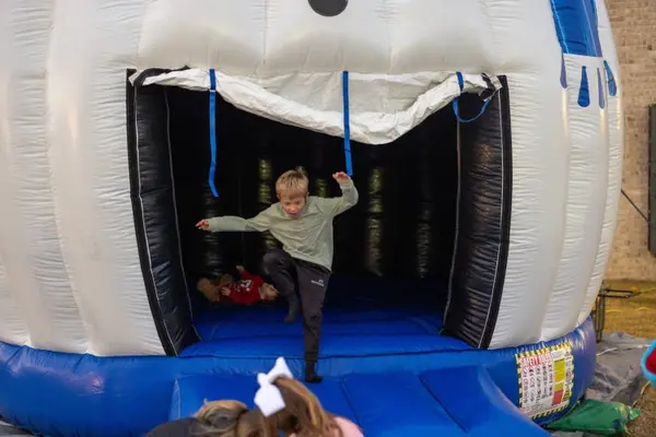 Child jumping inside an inflatable snowman bounce house