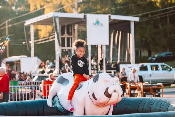 Girl riding a mechanical bulldog at a party event