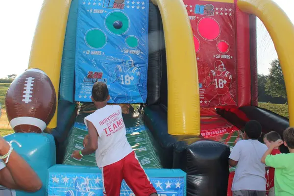 Kids playing inflatable football quarterback challenge game