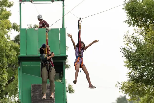 Girl soaring on a zipline ride at an outdoor event