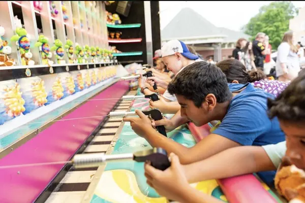 Children playing water gun carnival games to win prizes