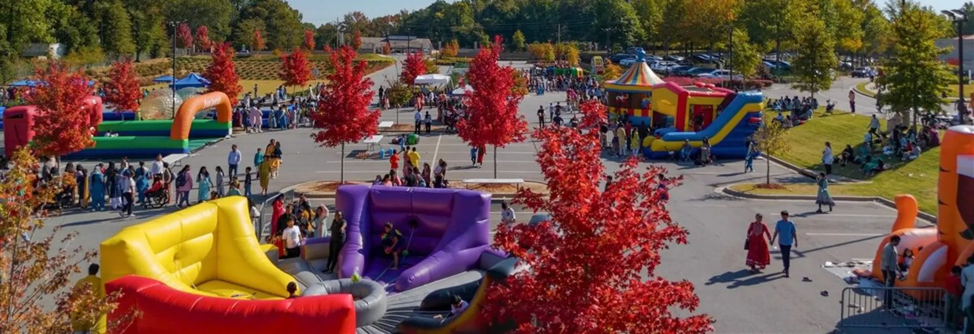 Fall festival with bounce houses, inflatable attractions, and carnival tents