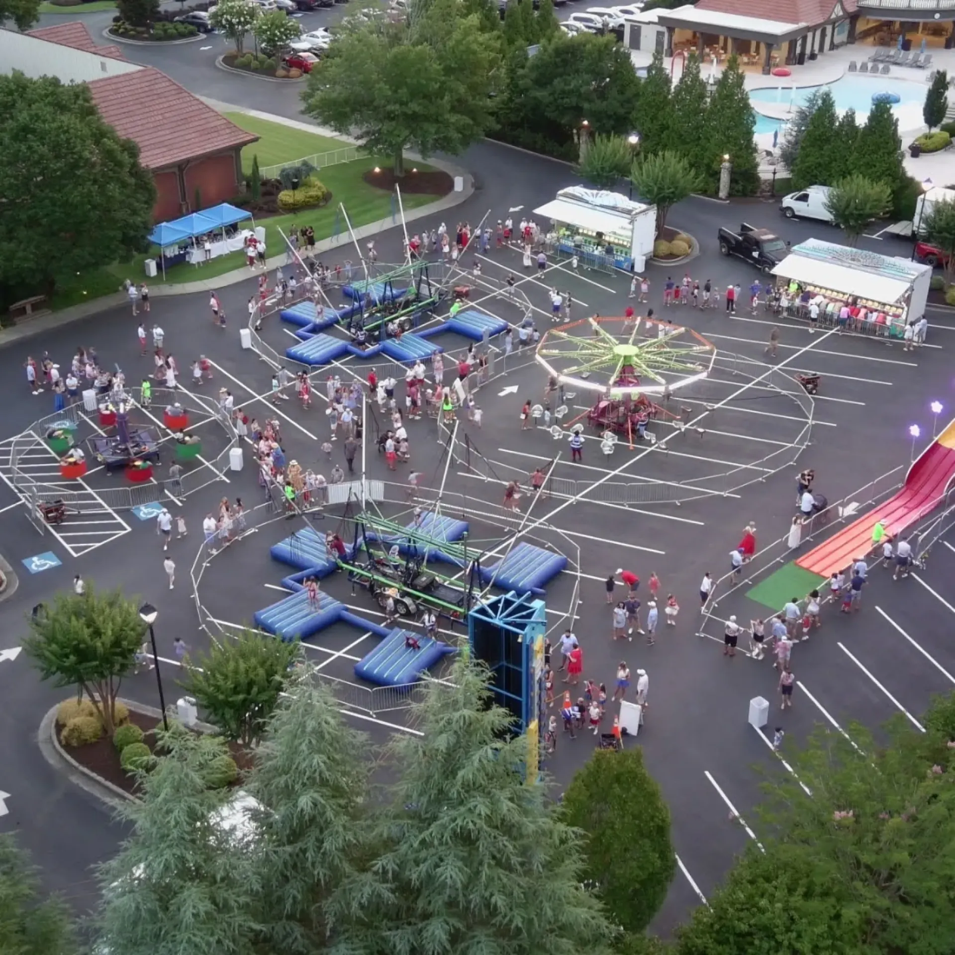 Aerial view of a jamboree event with carnival games, rides, and attendees